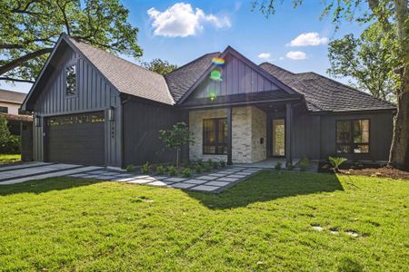View of front facade with a front yard, roof with shingles, driveway, and board and batten siding View of front facade with a front yard, roof with shingles, driveway, and board and batten siding