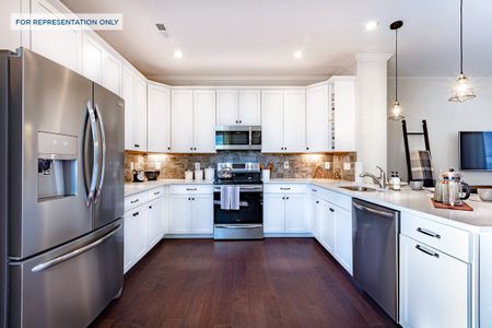 Kitchen with quartz countertops and stainless steel appliance is open to the great room.