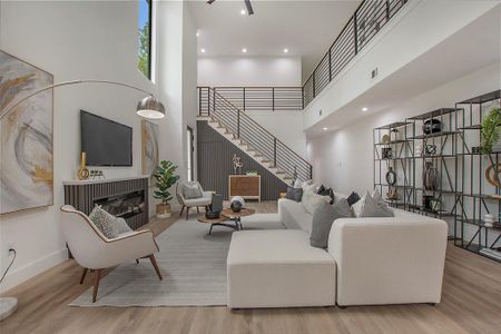 Living room featuring a high ceiling and light hardwood / wood-style flooring