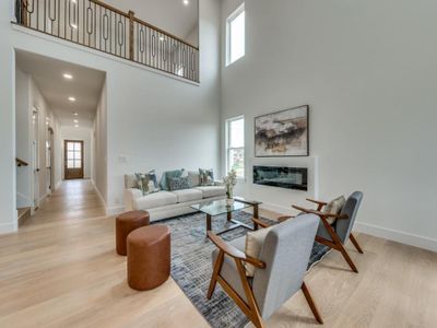 Living room with a towering ceiling and light wood-type flooring