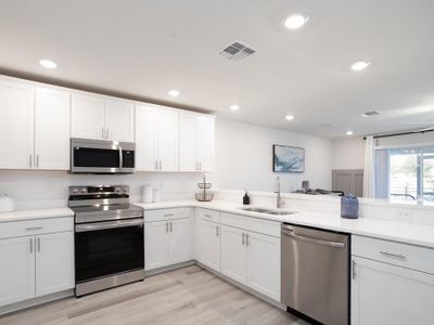 The large kitchen includes ample cabinet and counter space, a pantry, and breakfast bar - Azalea townhome by Highland Homes