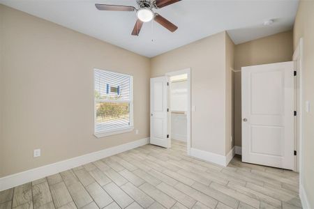 Unfurnished bedroom with a closet, ceiling fan, light hardwood / wood-style flooring, and a spacious closet