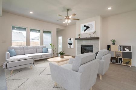 Living room with a tile fireplace, ceiling fan, and hardwood / wood-style floors