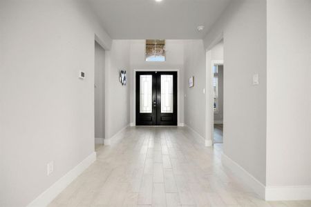 A welcoming foyer featuring elegant tall double front doors