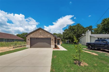 View of front of house featuring a garage and a front lawn