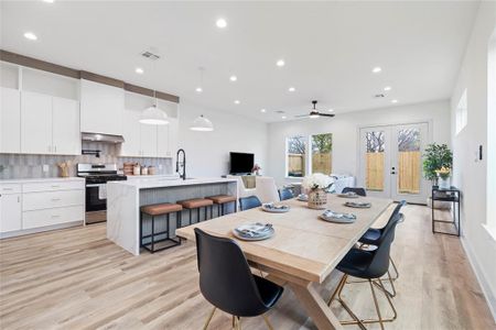 A bright, airy living room featuring high ceilings, large windows for natural light, and elegant recessed lighting.