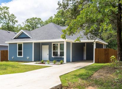 View of front facade with a front lawn, a porch, and a carport