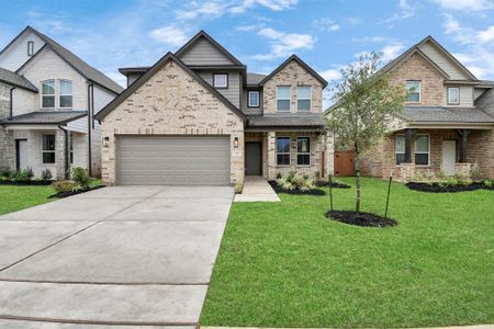 This home boasts lush green grass and meticulous landscaping. Its premium elevation showcases an exquisite blend of brick and stone features, complemented by modern coach lighting