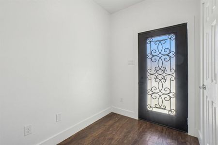 Entryway with dark wood-type flooring and coat closet