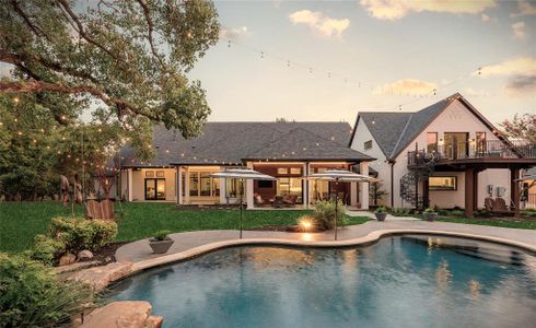 Pool at dusk featuring a lawn and a patio area