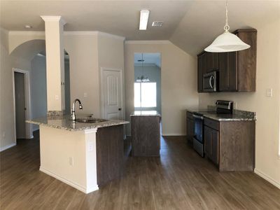 Kitchen featuring kitchen peninsula, stainless steel appliances, light stone countertops, and dark hardwood / wood-style floors