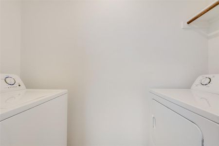 Clothes washing area featuring washer and clothes dryer