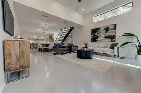 Living room with visible vents, finished concrete flooring, and stairs