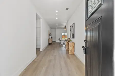 Hallway with recessed lighting, visible vents, light wood-style flooring, and baseboards