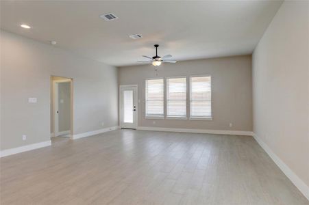 Empty room with light hardwood / wood-style floors and ceiling fan