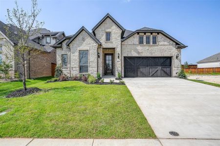 French country style house with a garage and a front lawn