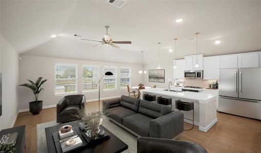 The main living area showcases stunning high vaulted ceilings with a ceiling fan, 4 main windows, and open living, dining, and kitchen space.