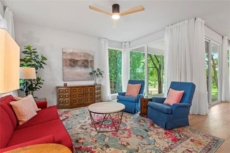 Living room with ceiling fan, wood-type flooring, and a wealth of natural light