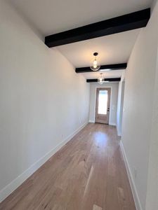 Entry with stained front and door and decorative beams and light fixtures.