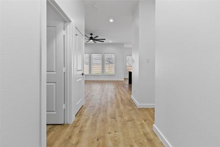 Corridor with recessed lighting, light wood-style floors, and baseboards