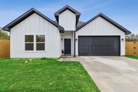 Modern inspired farmhouse featuring a garage and a front yard