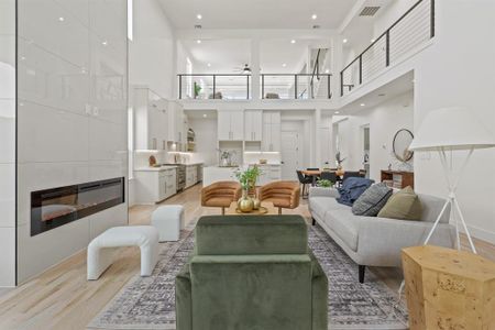 Living room with light wood-type flooring and a towering ceiling