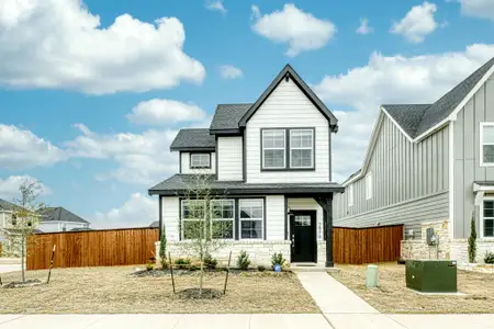 View of front of property with a shingled roof, stone siding, central AC, and fence