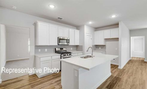 Kitchen with white cabinetry, appliances with stainless steel finishes, and sink