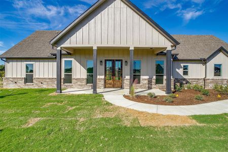 Rear view of house with covered porch and a yard