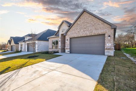 View of front facade with a yard and a garage