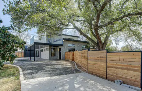 View of front facade with stone siding, a patio area, and fence