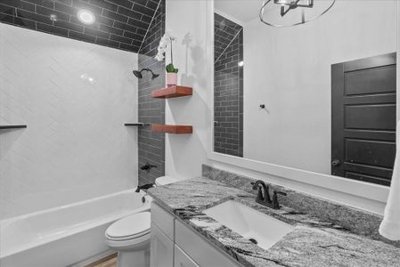 Bathroom with toilet, vanity, and washtub / shower combination