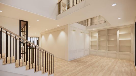 View of foyer with staircase to the left and a formal living space/study with a library above.