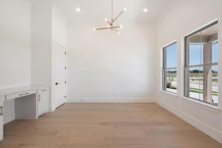 Spare room with light hardwood / wood-style floors, a notable chandelier, and ornamental molding