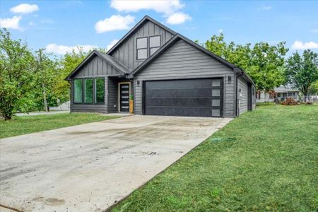 View of front facade with a front lawn and a garage