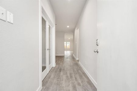 The grand entrance beckons with high ceilings, adorned with elegant wood-look tile flooring and oversized baseboards. Sample photo of completed home with similar floor plan. As-built interior colors and selections may vary.