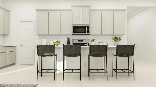 Kitchen featuring a breakfast bar, range, backsplash, and light tile patterned floors