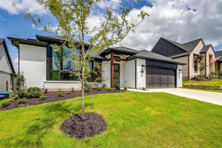 View of front of house with a front lawn and a garage