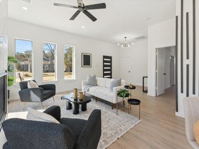 Living room with recessed lighting, baseboards, visible vents, light wood-type flooring, and ceiling fan with notable chandelier