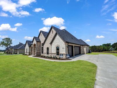 View of front of property featuring a garage and a front yard