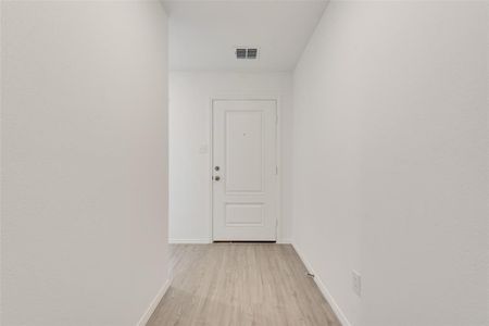 Corridor with light hardwood / wood-style flooring