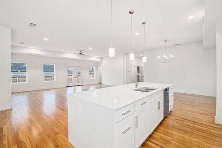 Kitchen featuring open floor plan, light wood-style flooring, visible vents, and a sink