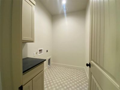 Washroom featuring hookup for a washing machine, electric dryer hookup, and cabinets