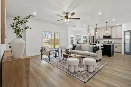 Living room featuring recessed lighting, ceiling fan with notable chandelier, visible vents, and light wood finished floors