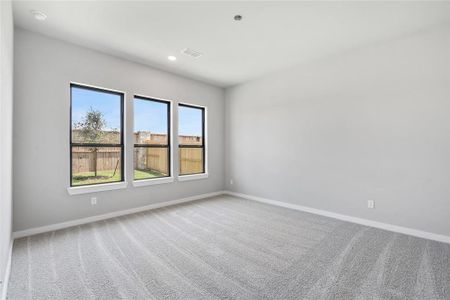 The primary bedroom is a spacious retreat, featuring large windows that flood the room with natural light. It offers a serene atmosphere, perfect for relaxation and unwinding after a long day.