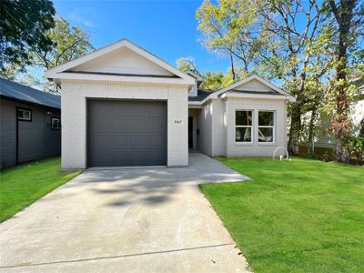 Single story home with a garage and a front lawn