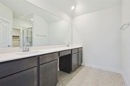 Bathroom featuring tile patterned flooring, vanity, and a shower with shower door