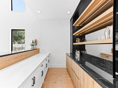 Kitchen featuring light stone countertops, light hardwood / wood-style floors, white cabinets, and light brown cabinetry