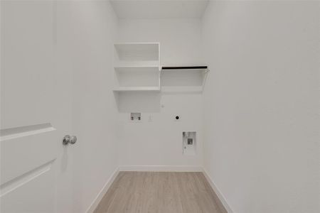 Laundry room with hookup for a gas dryer, light hardwood / wood-style floors, hookup for an electric dryer, and washer hookup