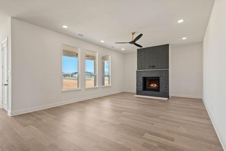 Unfurnished living room featuring ceiling fan, recessed lighting, a fireplace, visible vents, and light wood-type flooring